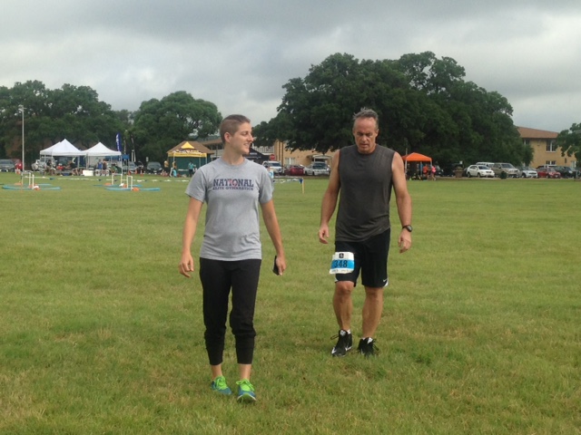 Trainer and athlete walk at event.