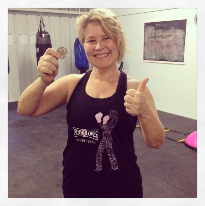 Leah Nyfeler holds up Pink Gloves Boxing Challenge Coin