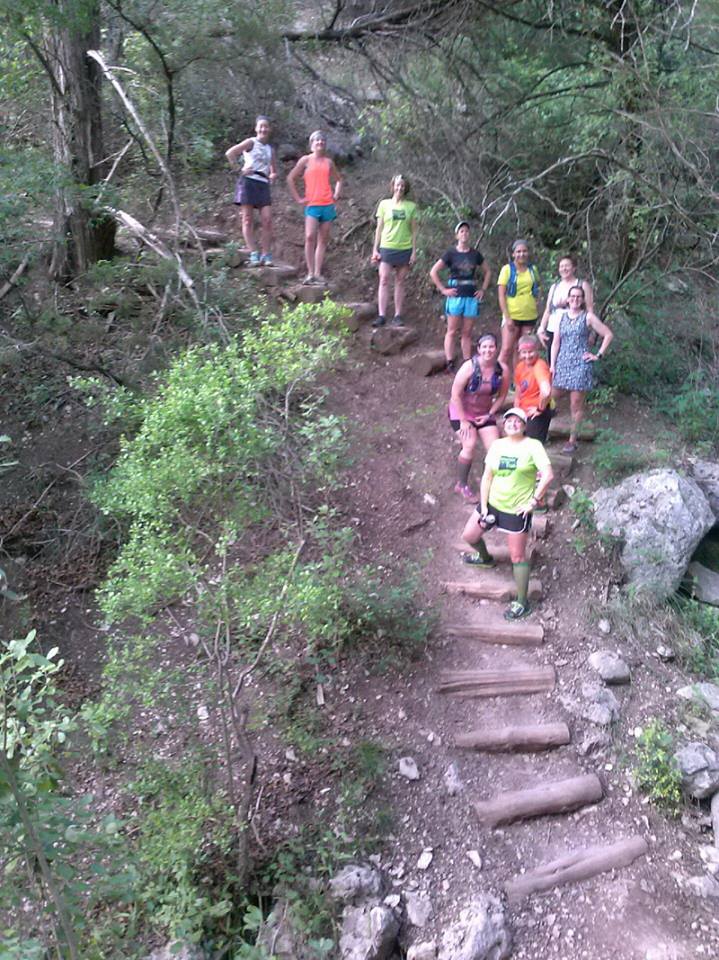 Women runners on hilly trail.