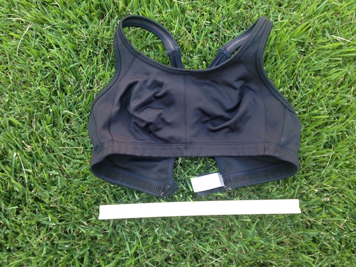 Old running bra on grass with ruler to show scale.