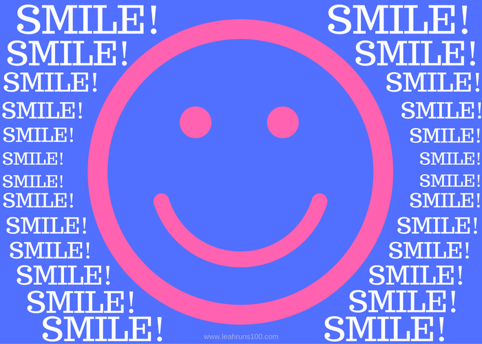 Pink happy face on blue background with words "SMILE!" surrounding.